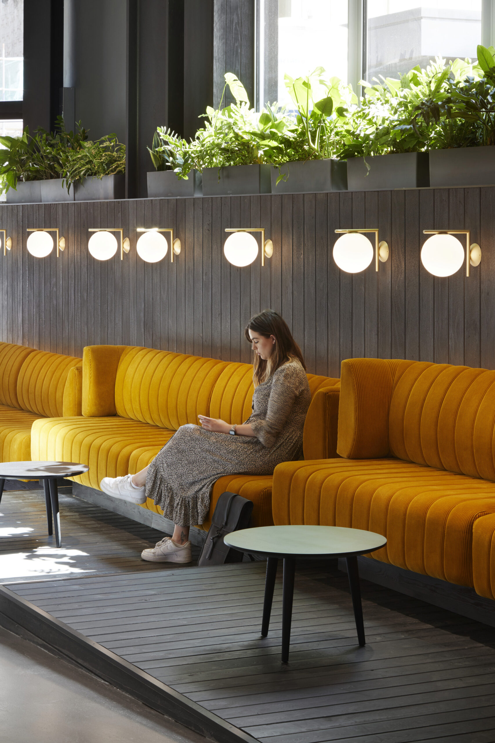 A woman sat on an orange sofa at Forge.