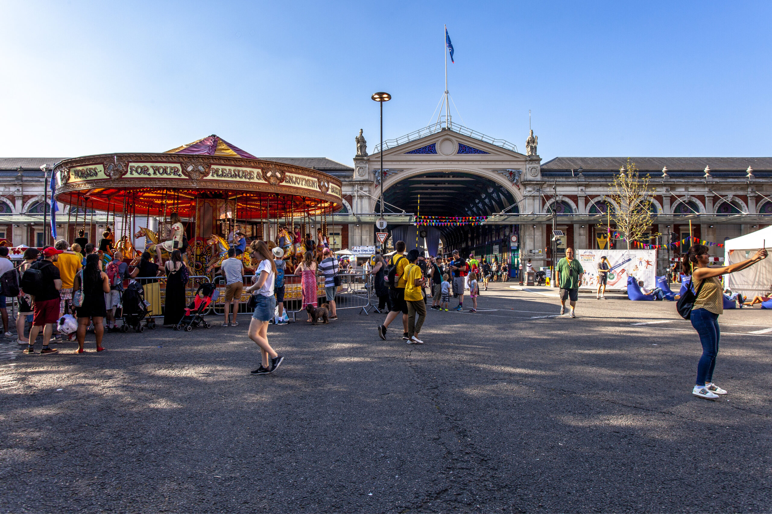 An image at the Smithfield public realm with merry go round and lots of people enjoying the ride