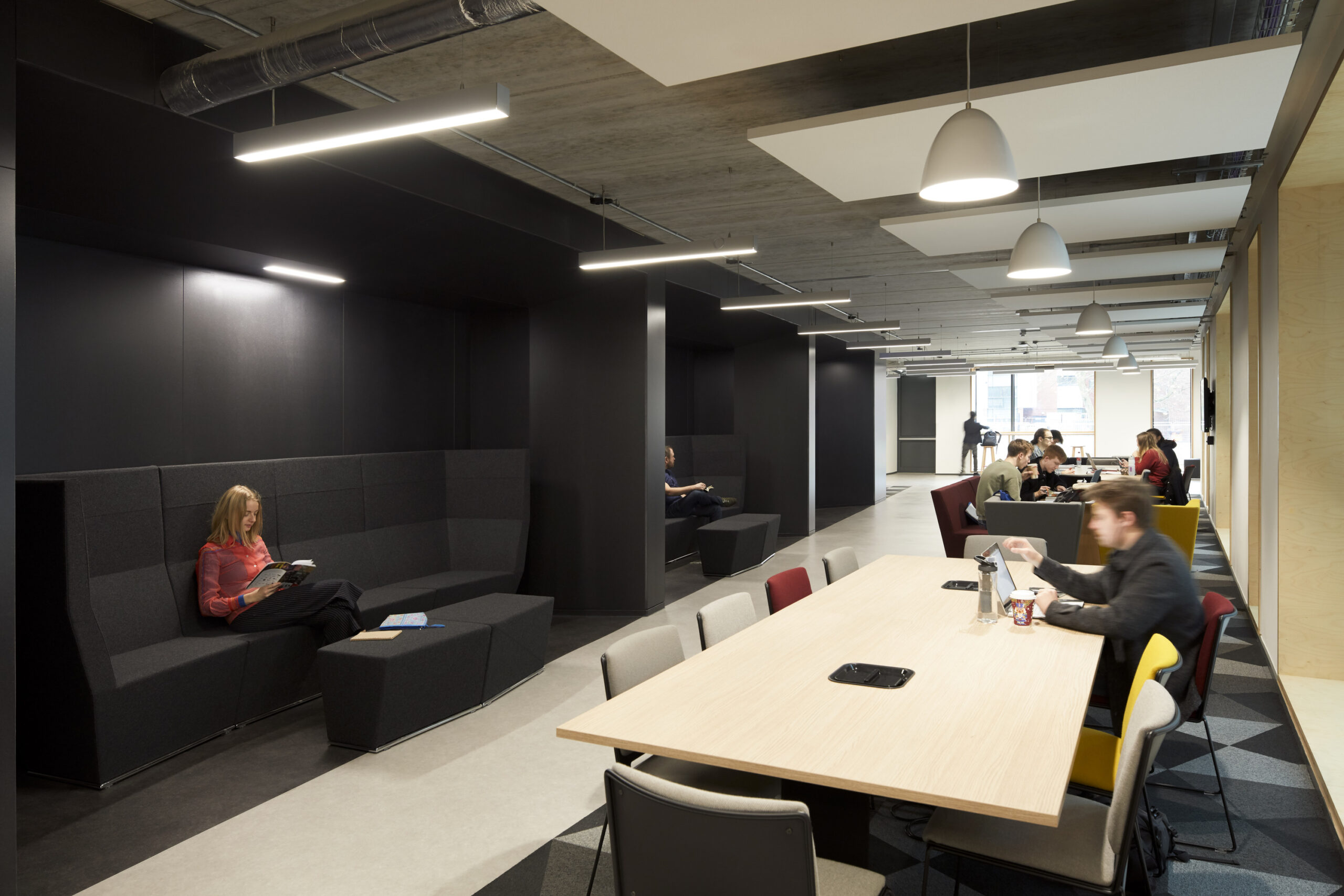 People sitting in breakout spaces within Ideas Mill at University of Manchester Schuster Annexe