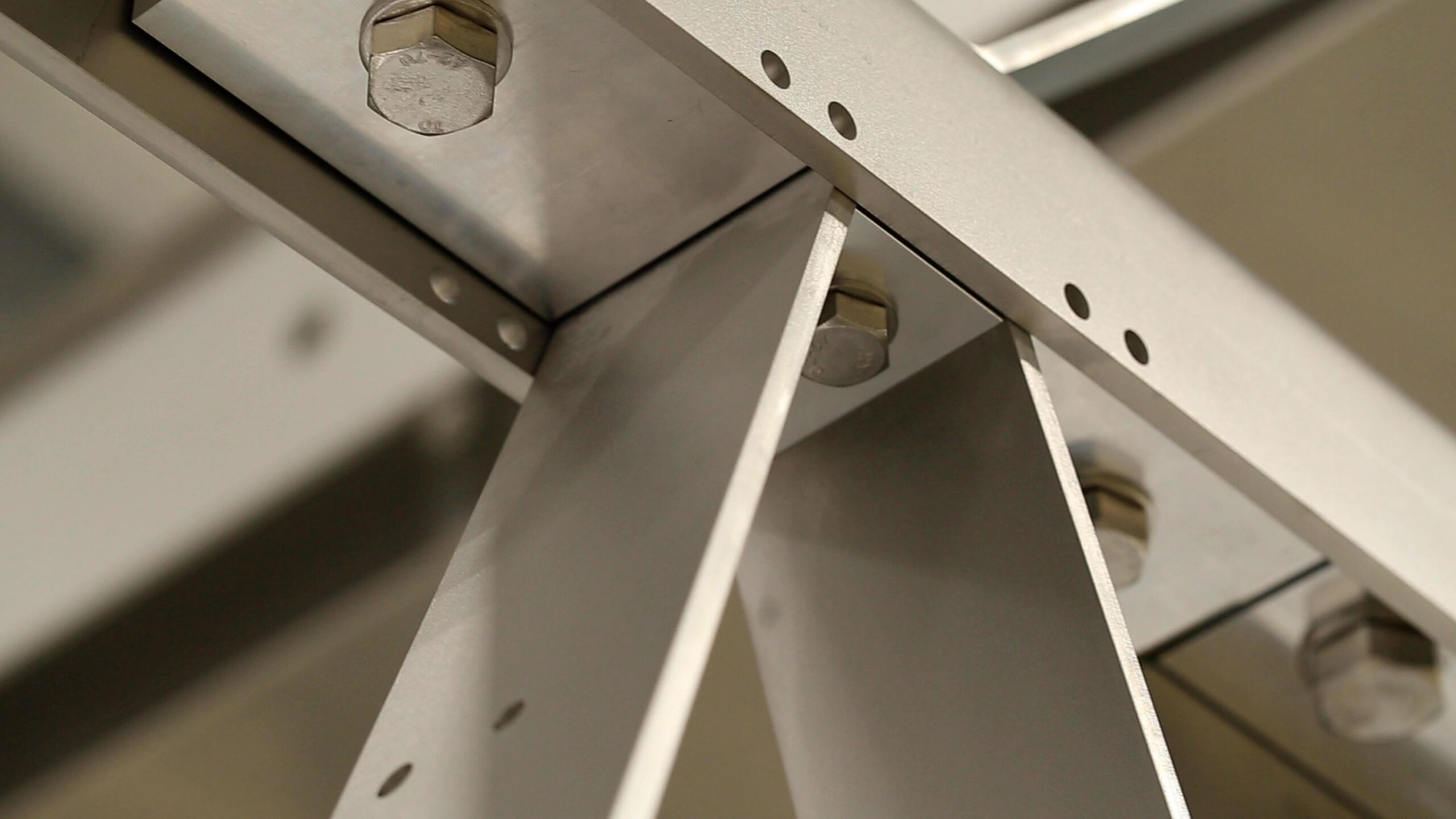 Detail shot of AVA Bridge components, including bolts, and bars of metal screwed together.