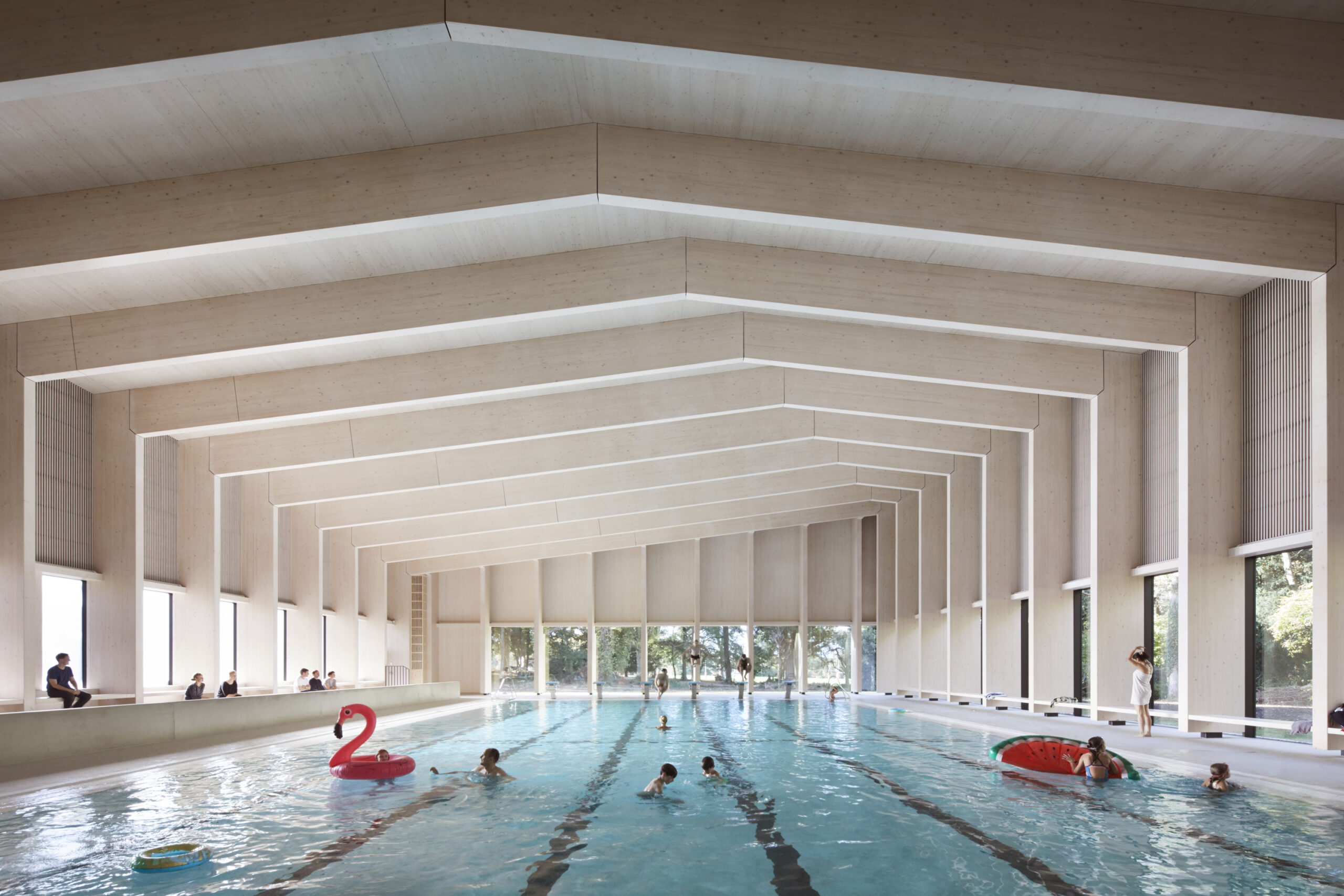 Swimming pool in use with flamingo and watermelon floats