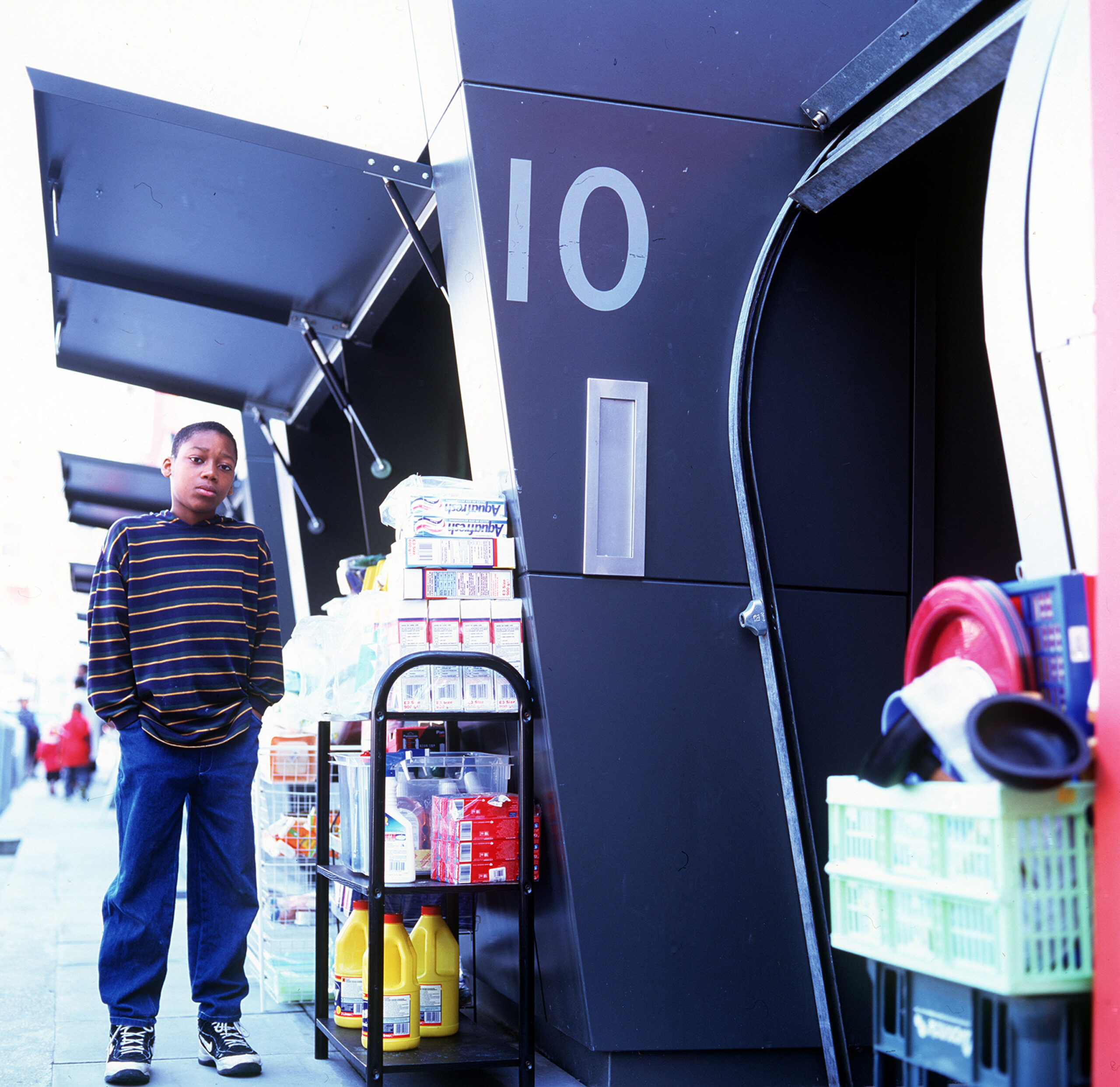 A young child posing outside a market pod at Gillett Square