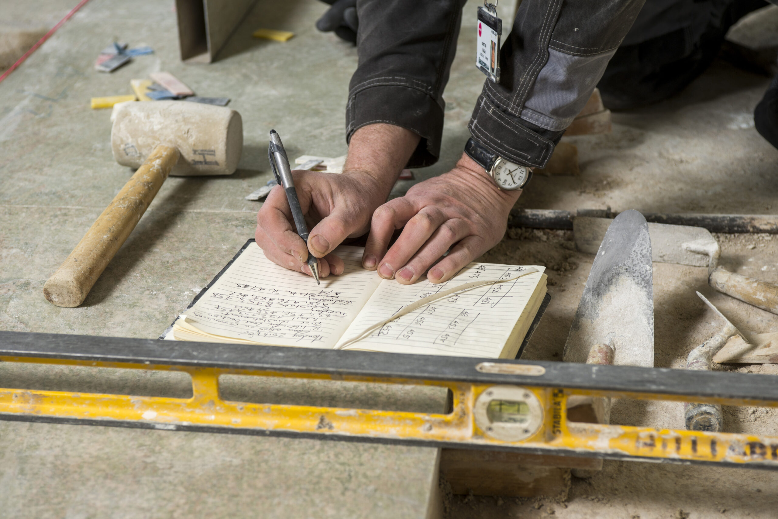 Interior close up of a construction worker writing in their book.