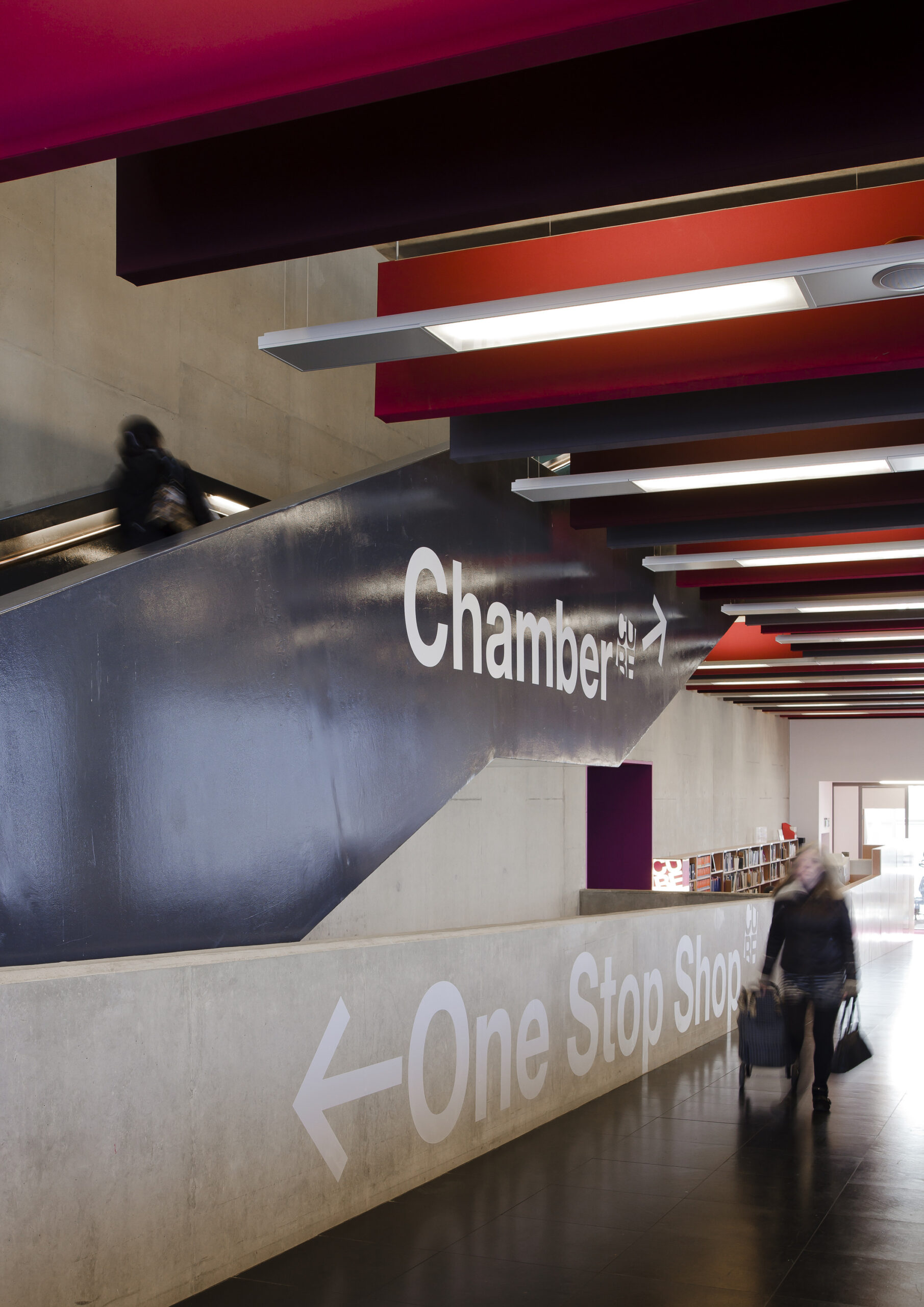 A person walking up the stairs to the chamber and another walking on ground floor to the one stop shop.