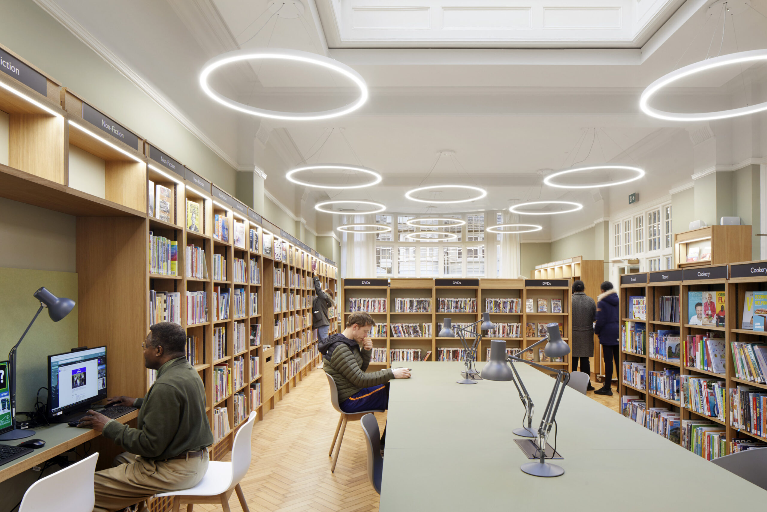 People sitting down, using the computers and walking around the library at Plumstead Centre